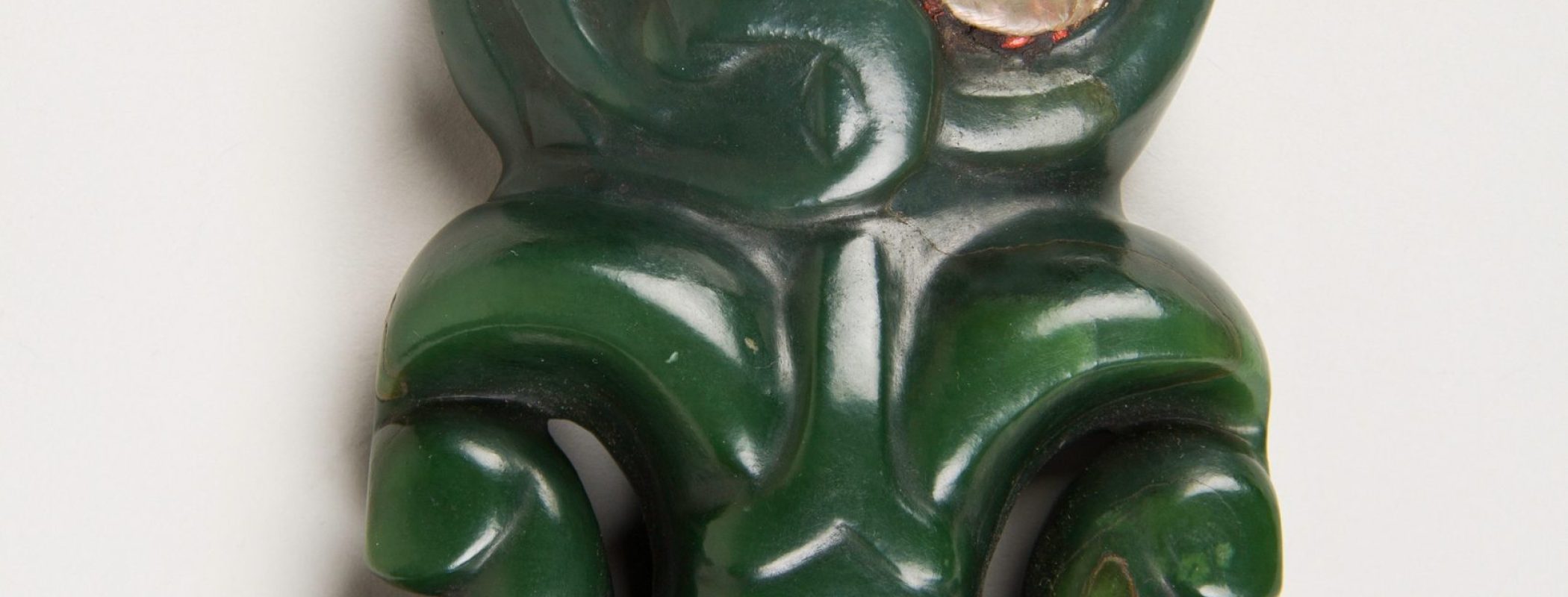 Figure 9:2. Hei tiki, nineteenth century, pounamu (nephrite jade with abalone inlay), 15.5 x 7.6 cm, The Metropolitan Museum of Art, New York City.  Hei tiki pendants were often worn in honour and acknowledgement of figures of one’s whakapapa, or ancestral lineage.
